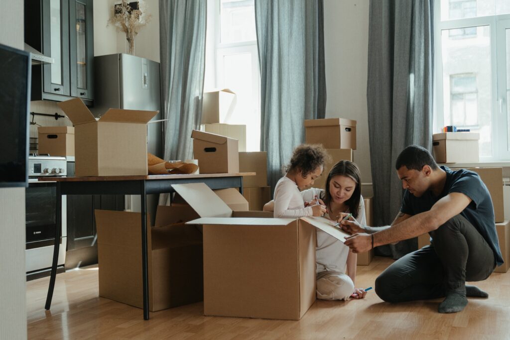 A family unpack cardboard boxes following a house move