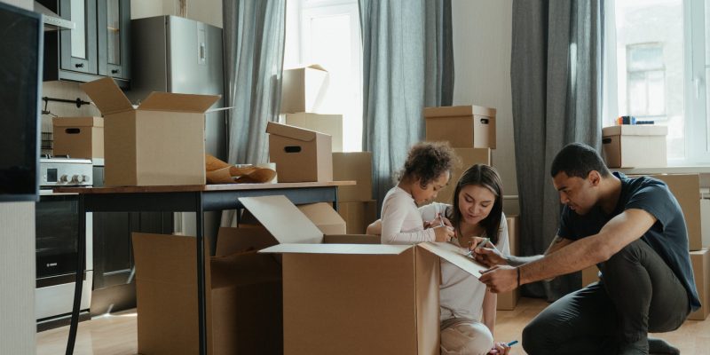 A family unpack cardboard boxes following a house move